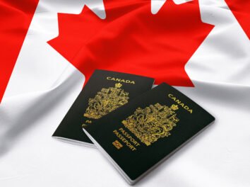 Canadian passports and flag as a symbol of self-employed persons program for independent workers to immigrate to Canada
